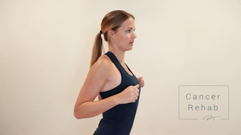 Female Physical therapist navy tank top doing shoulder and scapular retractions for arm lymphedema