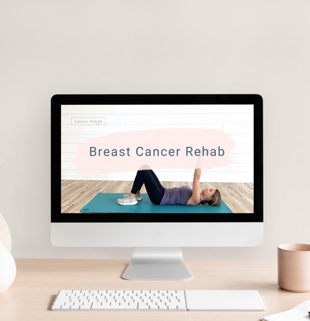desktop with keyboard on light colored table. on screen says Breast Cancer Rehab with woman laying on blue yoga mat