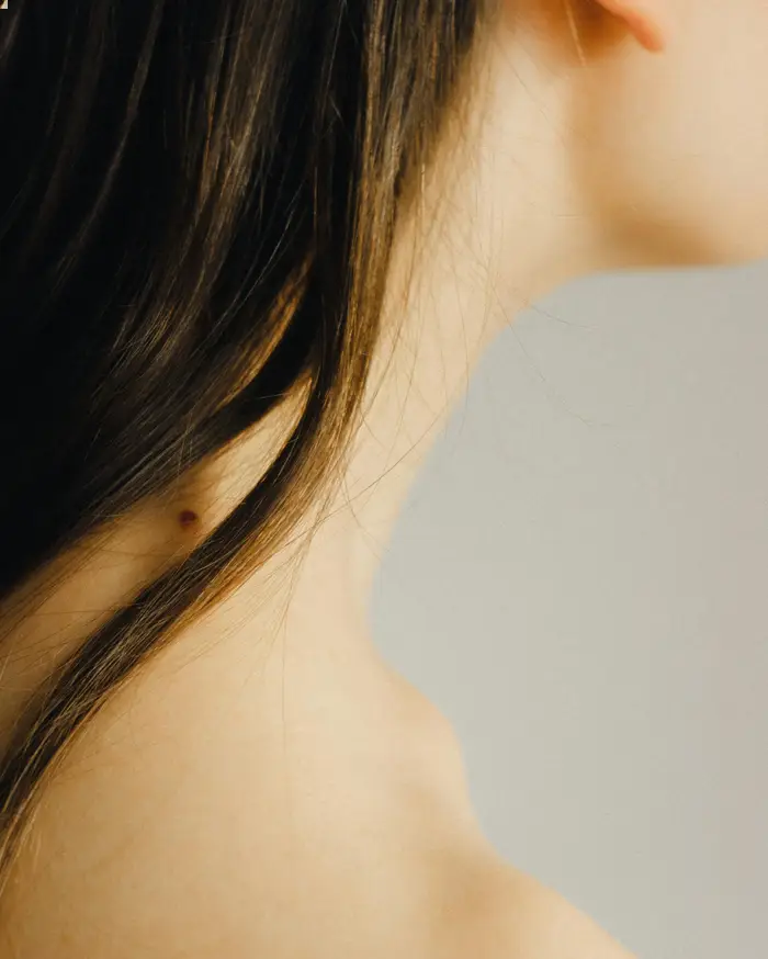 woman with dark hair , closeup of side of neck