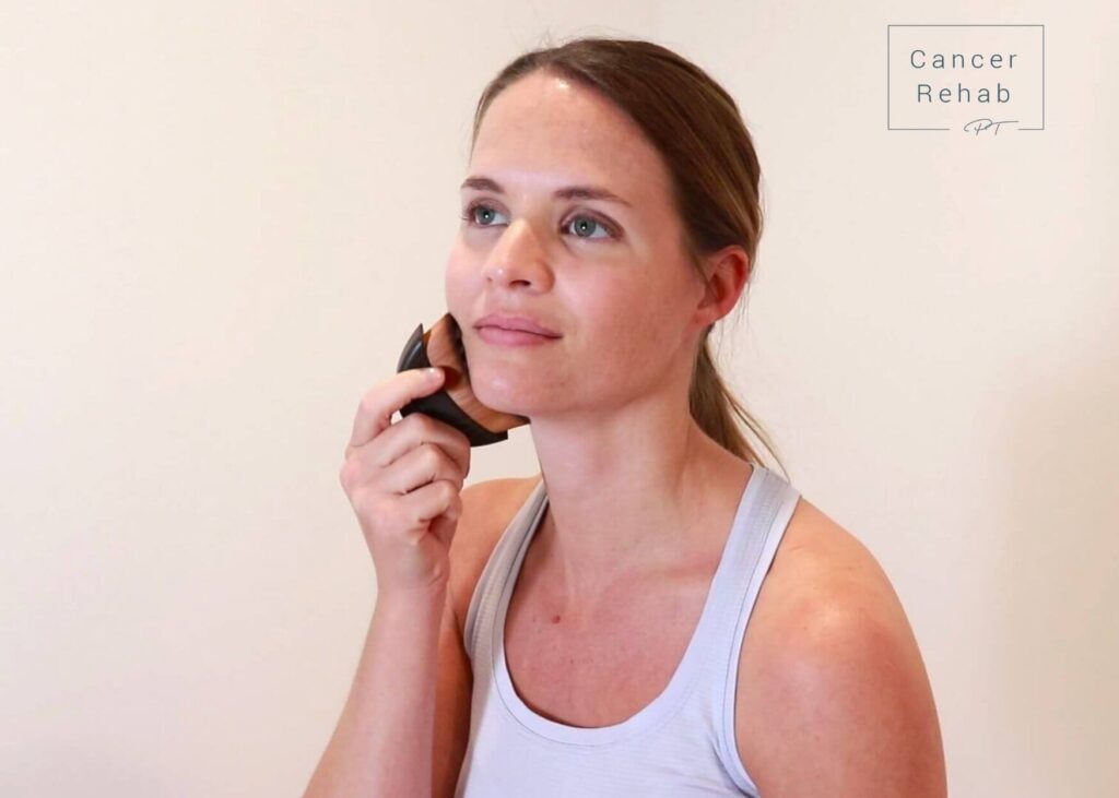 Kelly Sturm dry brushing her face to experience the dry brushing benefits.