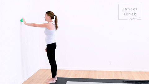 animated clip of physical therapist standing in front of a wall. left arm straight out in front holding a green ball to the wall, doing small circles