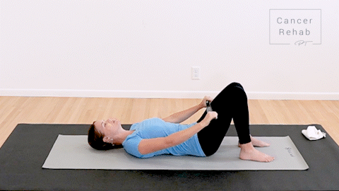 animated clip of a physical therapist lying on a yoga mat, raising a dowel up overhead with both arms.