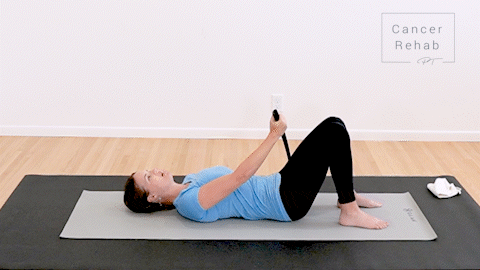 animated clip of a physical therapist lying on a yoga mat, guiding a dowel up over her right shoulder