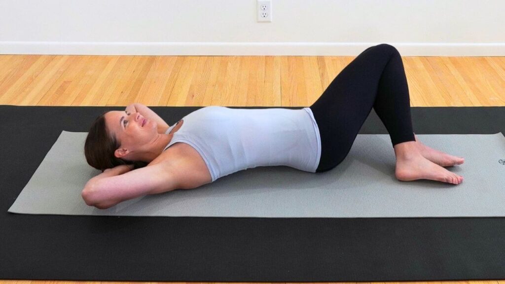 physical therapist lying on a mat on the floor demonstrating breast cancer exercises after surgery