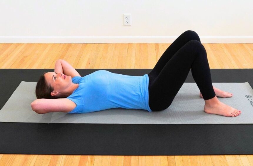 a physical therapist lying on a yoga mat demonstrating exercises after breast cancer surgery