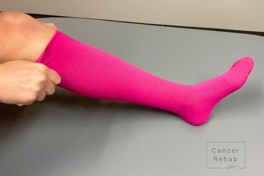 pulling on a compression sock to the knee