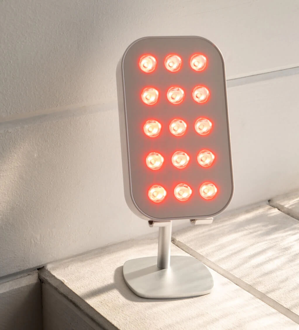 the lumebox 2.0 red light box on a stand on a table