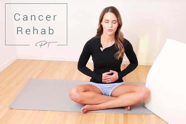 A certified lymphedema therapist sitting on a mat and taking deep belly breaths to begin a manual lymphatic drainage routine.