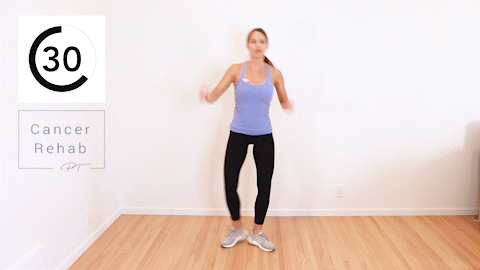 A woman extending her leg as she reaches across her body.