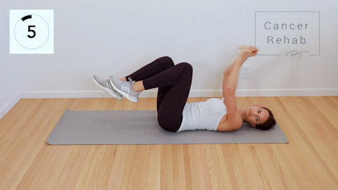 A certified lymphedema therapist lying on her back as extends opposite arm and leg out and then comes back to center, switching sides.
