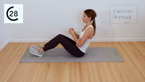 A certified lymphedema therapist Sitting down on a mat and twisting her trunk to the left and right.