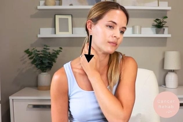 A woman using her hand to massage fluid in her neck.