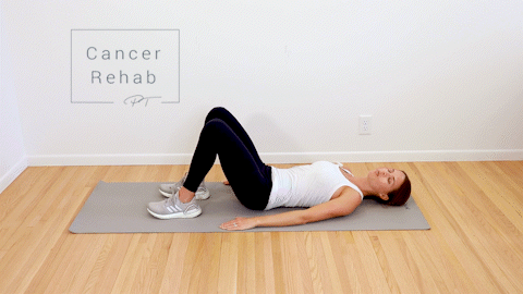 A woman lying on her back doing a bridge exercise as she lifts her arms above her head.