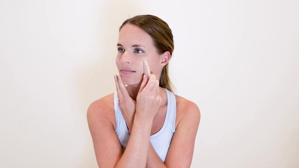 Sweeping your cheeks for lymphatic drainage.